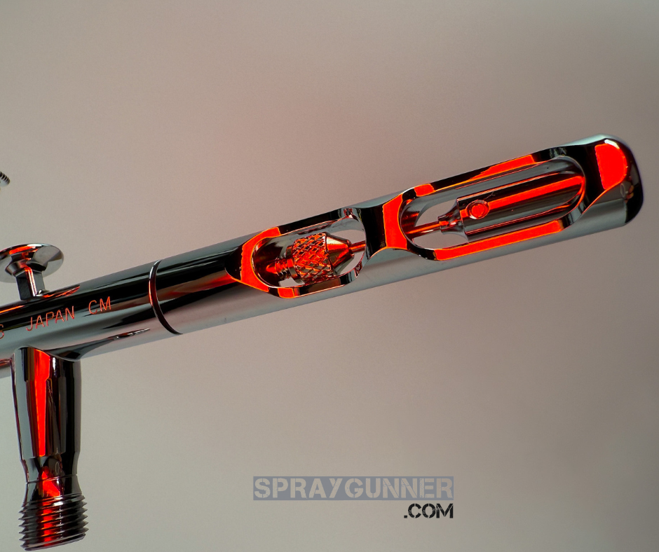 A branded packaging box displays the open, nozzle-equipped IWATA VAULT KUSTOM CS Gravity Feed Dual Action Airbrush with a chrome body.