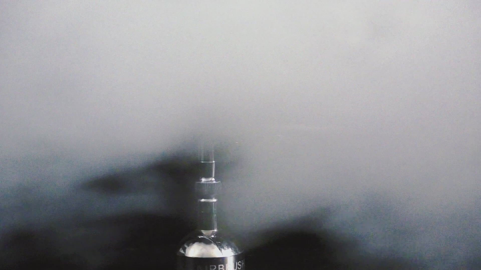 Airbrush spraying fine mist, demonstrating the precision and smooth performance of the Harder & Steenbeck CRPlus 2in1 for professional applications.