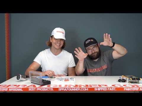 Two people presenting the GSI Creos Mr. Hobby Procon Boy PS-290 airbrush in a video review, discussing its features and performance.